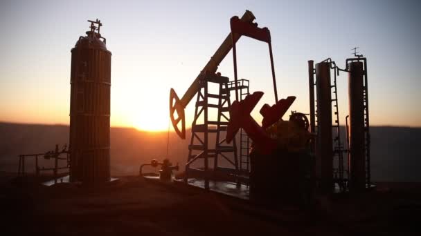 materiał sylwetkowy pompy olejowej i rafinerii ropy naftowej o zachodzie słońca - Materiał filmowy, wideo