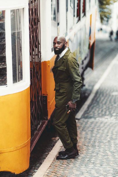 A black fancy guy and a yellow tram - Foto, Imagen