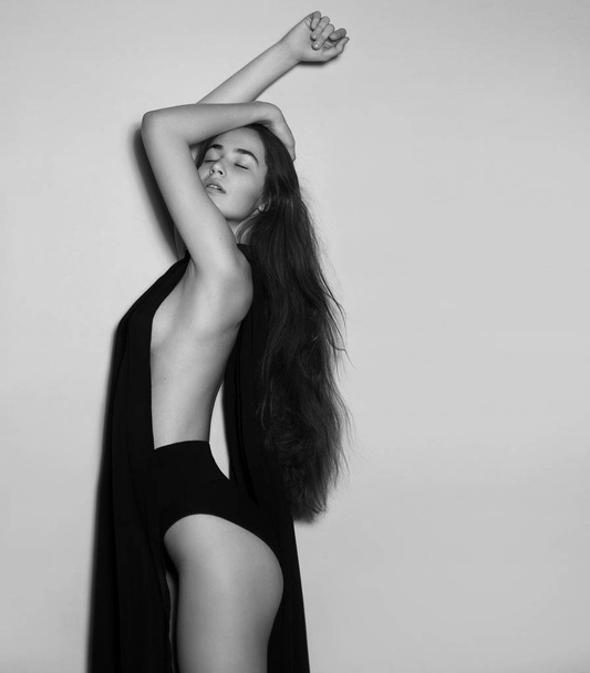 Girl with long hair posing in black cloth - Fotó, kép