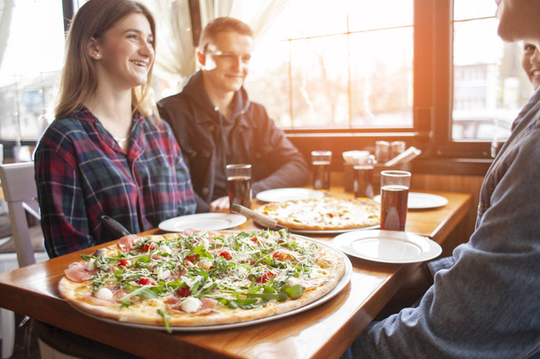 luokkatovereiden ystävät syövät pizzaa pizzeriassa, lounasoppilaat syövät pikaruokaa
 - Valokuva, kuva