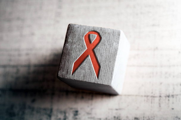 Rode Aids en Hiv lint op een houten blok op een tafel - Foto, afbeelding