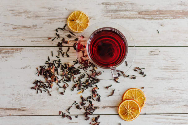 Cup of hibiscus tea (karkade, red sorrel, Agua de flor de Jamaica) on a table. - Фото, зображення