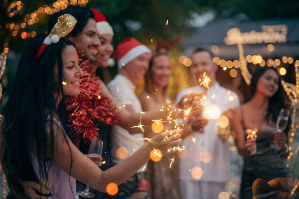 A large company has fun with champagne and sparklers in the tropics. - Photo, Image