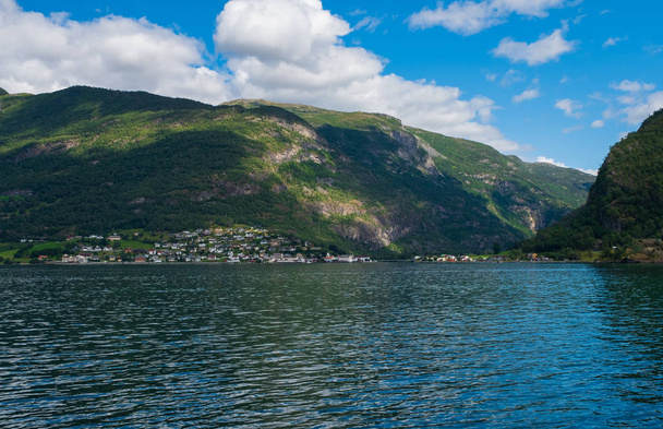 Het dorp Aurlandsvangen aan de kust van de Sogne fjord Aurlands fjord in Noorwegen. juli 2019 - Foto, afbeelding