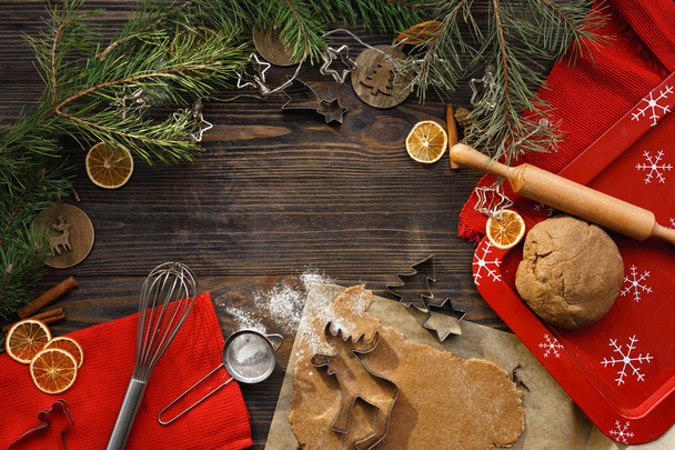Baking background. Ingredients and kitchen tools for preparation of the Christmas cookies. Christmas atmosphere on a dark wood background, top view. Flat lay - Fotoğraf, Görsel