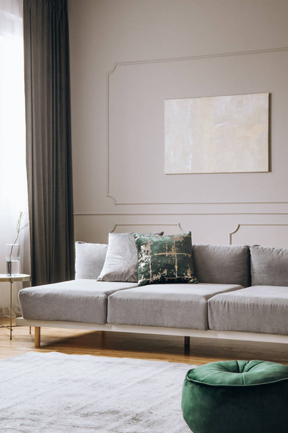 Elegant living room interior with comfortable sofa, real photo - Fotó, kép