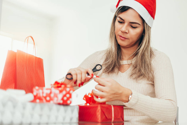 Christmas santa woman preparing gifts wrapping paper for holidays - Photo, Image