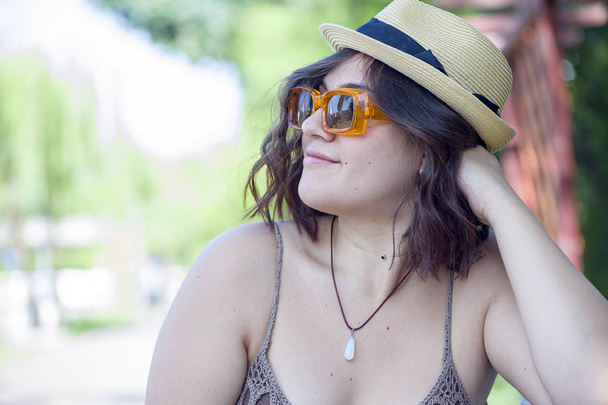 Portrait of a woman wearing retro glasses and a straw hat - Photo, image