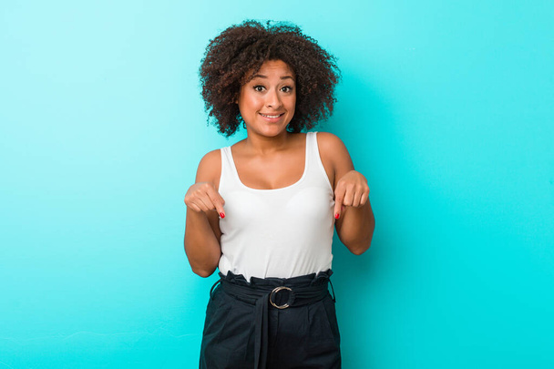 Fiatal afro-amerikai nő mutat le ujjaival, pozitív érzés. - Fotó, kép