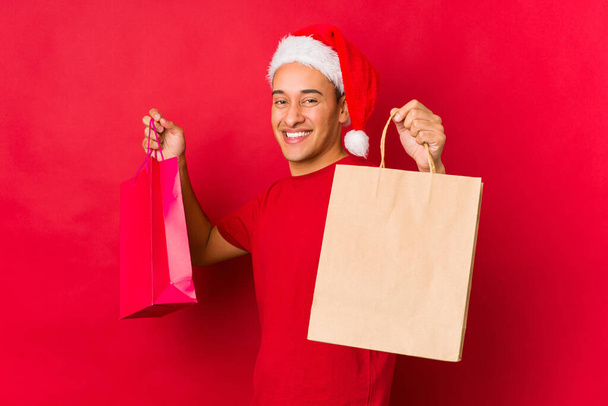Młody człowiek trzyma prezent w Boże Narodzenie - Zdjęcie, obraz