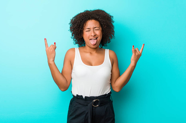 Young african american woman showing rock gesture with fingers - Foto, afbeelding
