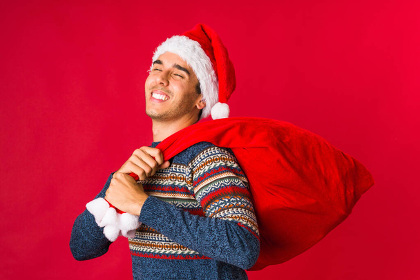 Young man holding a gift on christmas day - Photo, image