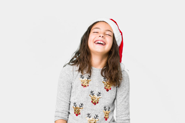 Pikkutyttö juhlii joulua päivä rento ja onnellinen nauraa, kaula venytetty näyttää hampaita
. - Valokuva, kuva