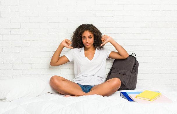 Giovane studentessa afroamericana sul letto si sente orgogliosa e sicura di sé, esempio da seguire
. - Foto, immagini