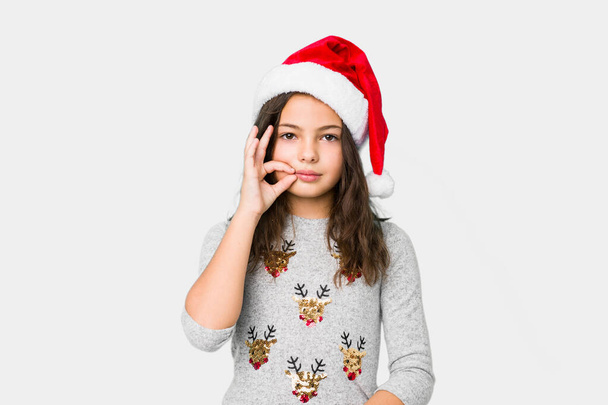 Bambina che celebra il giorno di Natale con le dita sulle labbra mantenendo un segreto
. - Foto, immagini