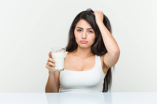 Mladá hispánka, která drží sklenici mléka v šoku, si vzpomněla na důležité setkání.. - Fotografie, Obrázek