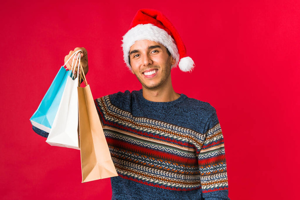 Young man holding a gift on christmas day - Foto, afbeelding