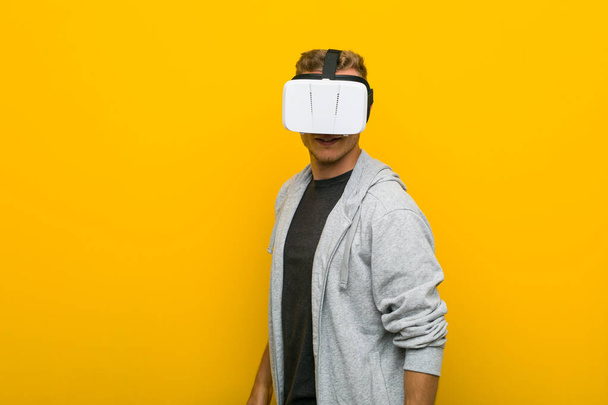 Young caucasian man using a virtual reality glasses - Foto, imagen