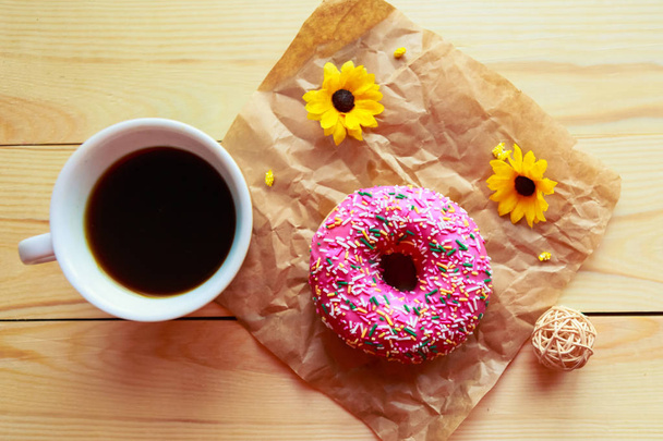Strawberry donut and coffee cup on wooden background, top view - Φωτογραφία, εικόνα