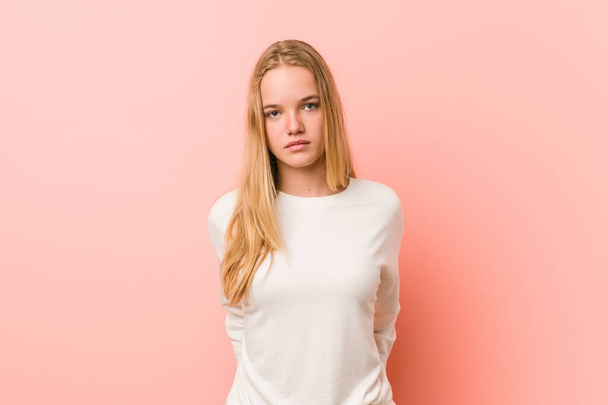 Caucasian teenager standing against a pink background - Photo, Image