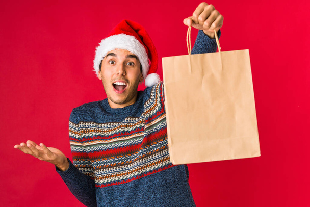 Young man holding a gift on christmas day - Photo, Image