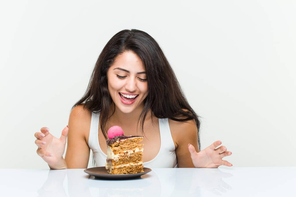 Νεαρή ισπανίδα γυναίκα τρώει ένα κέικ καρότο - Φωτογραφία, εικόνα