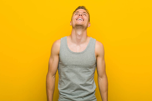 Молодий білий спортсмен розслаблений і щасливий сміється, шия розтягується, показуючи зуби
. - Фото, зображення
