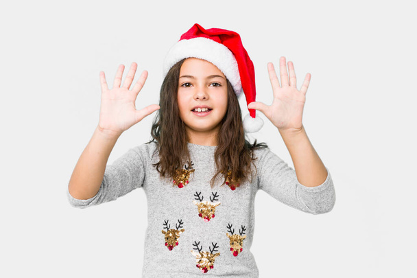 Niña celebrando el día de Navidad mostrando el número diez con las manos
. - Foto, Imagen