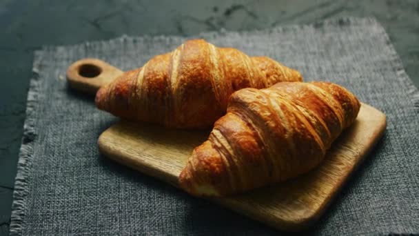 Tuoreet croissantit leikkuulaudalla
 - Materiaali, video