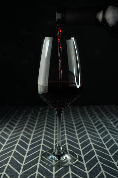 Bir kadeh kırmızı şarap ve bardakta içki. - Fotoğraf, Görsel