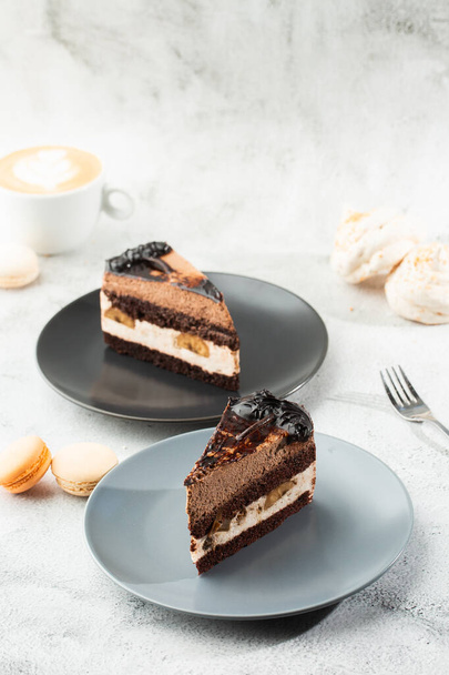 Banana chocolate cake on gray plate on marble background. Selective focus. Vertical photo. Menu for bakery. cafe menu. Pastry. Delicious and sweet dessert at cafe restaurant. - Foto, Imagem
