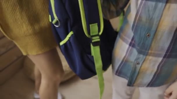 Mother carrying child to school and giving him a backpack. - Filmmaterial, Video