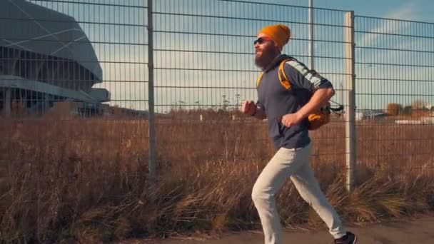 Hipster sports man jogging in city. Urban active life - Materiał filmowy, wideo
