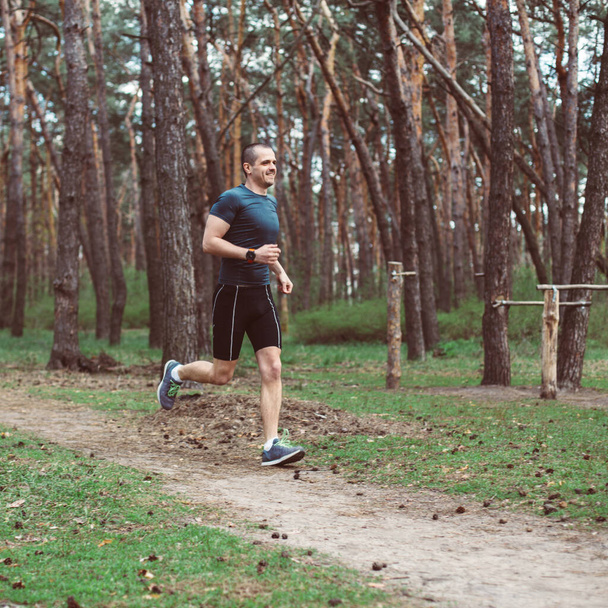 Αθλητής τρέχει στο πευκοδάσος - Φωτογραφία, εικόνα