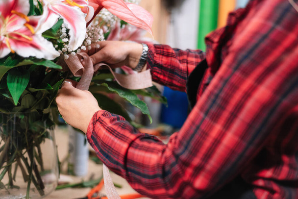 Young female florist with bouquet working in flower shop. - Photo, Image