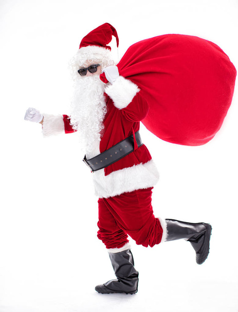 Santa Claus carrying sack full of gifts - Фото, зображення