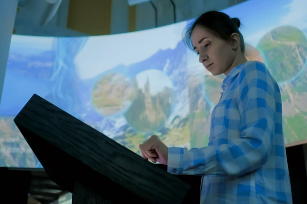 Frau nutzt interaktives Touchscreen-Display im Museum für moderne Geschichte - Foto, Bild