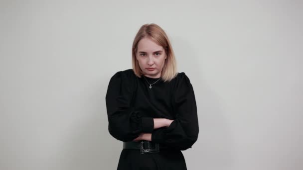 Jeune femme stricte, foulard tenant les mains croisées isolé sur un mur blanc
 - Séquence, vidéo