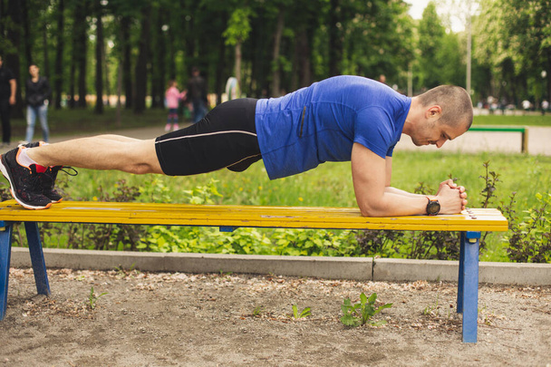 Mann macht Planken-Übung auf der Bank - Foto, Bild