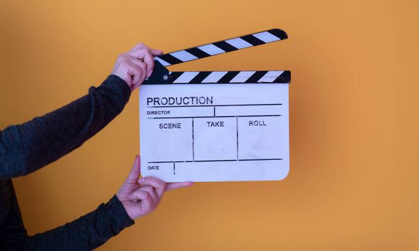 movie clapper on yellow background - Foto, afbeelding