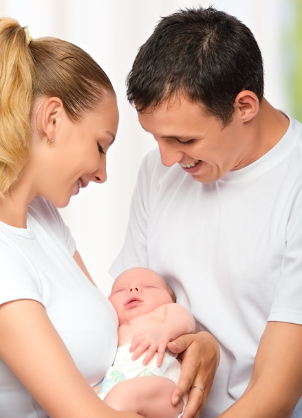 happy young family of mother, father and newborn baby in their a - Photo, Image