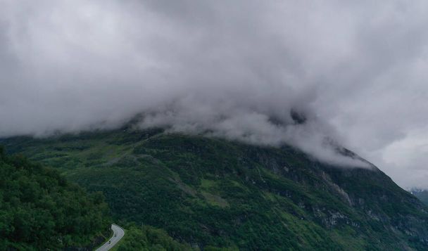 ノルウェーの有名な道路Trollstigenの上部では、素晴らしい山々を背景に美しい雲があります。2019年7月 - 写真・画像