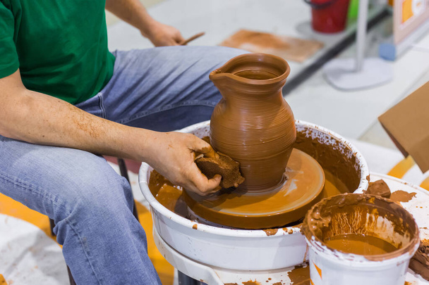 Professional potter shaping pot in pottery workshop - Photo, Image