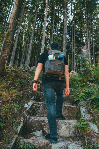 férfi hátizsák sétál kő lépcsőn vezet az erdőbe - Fotó, kép