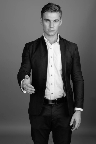 Портрет молодого привлекательного бизнесмена в черно-белом костюме
 - Фото, изображение