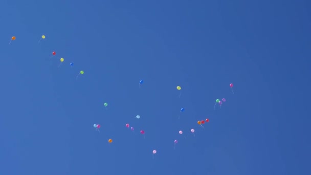 Bunte Luftballons fliegen in den Himmel, rot blau gelb orange rosa. viele bunte Ballons, die in der Luft fliegen. Geburtstags-Konzept. das Konzept eines schönen Urlaubs. - Filmmaterial, Video
