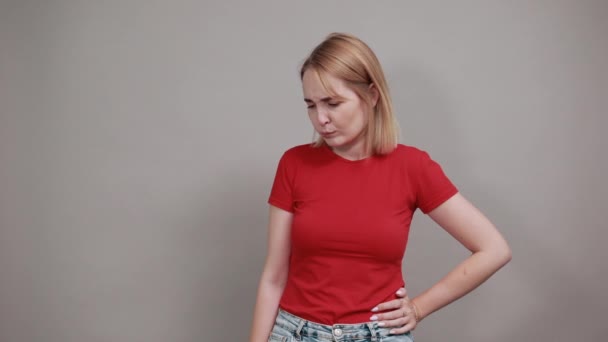 Besorgte, nervöse junge Frau mit beißenden Lippen an grauer Wand - Filmmaterial, Video