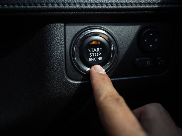 Start-Stop przycisk silnika z pomarańczowym światłem na konsoli czarny samochód  - Zdjęcie, obraz