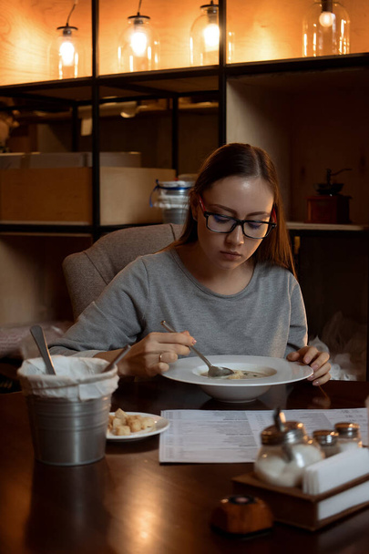 Fiatal nő eszik levest a kávézóban - Fotó, kép