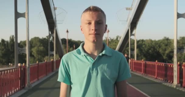 Smiling teenager 15, 16 years old blond boy posing looking at the camera - Video, Çekim